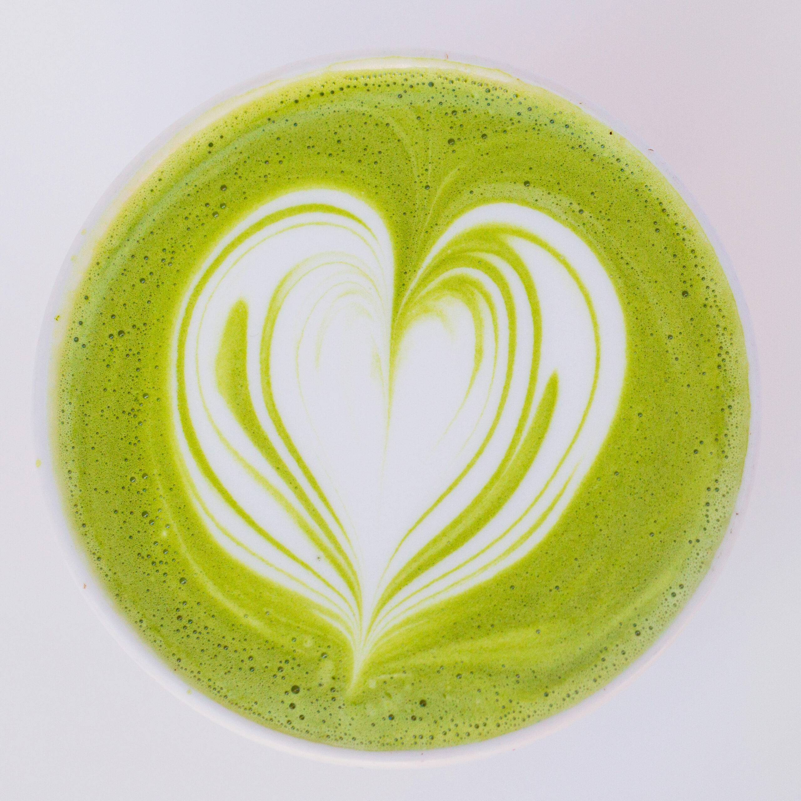 Matcha latte with heart-shaped foam art.